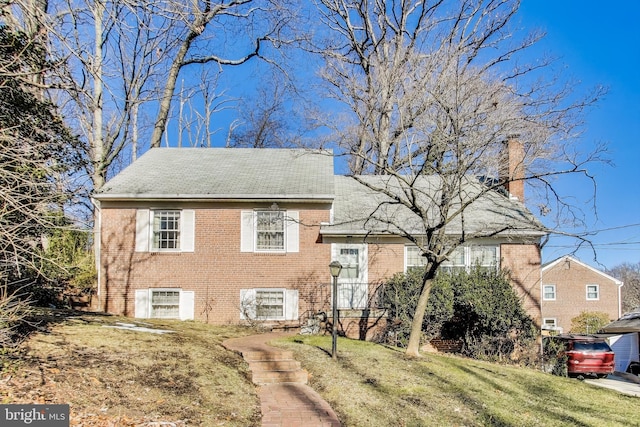 tri-level home with central AC unit and a front lawn