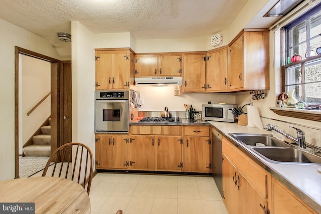 kitchen featuring appliances with stainless steel finishes, sink, and a textured ceiling