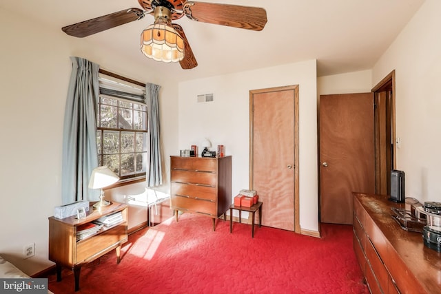 sitting room with dark colored carpet and ceiling fan