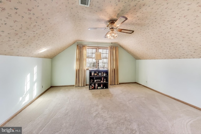 additional living space featuring lofted ceiling, a textured ceiling, carpet floors, and ceiling fan