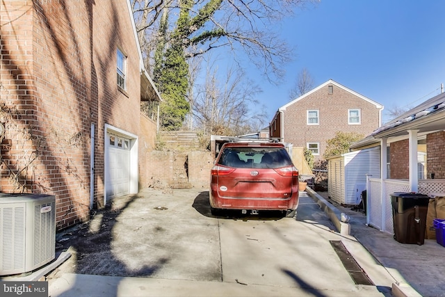 view of side of property featuring a garage and central AC