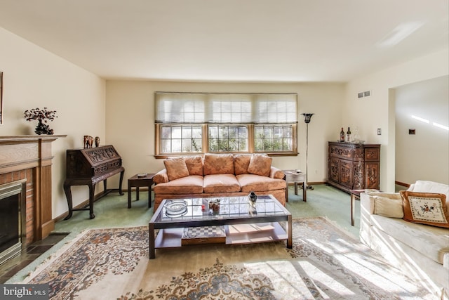 carpeted living room with a brick fireplace