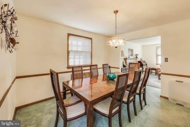 dining space with carpet flooring and a notable chandelier