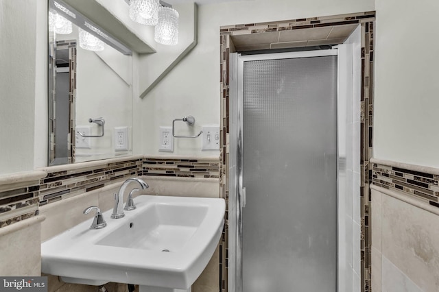 bathroom featuring sink, tile walls, and an enclosed shower