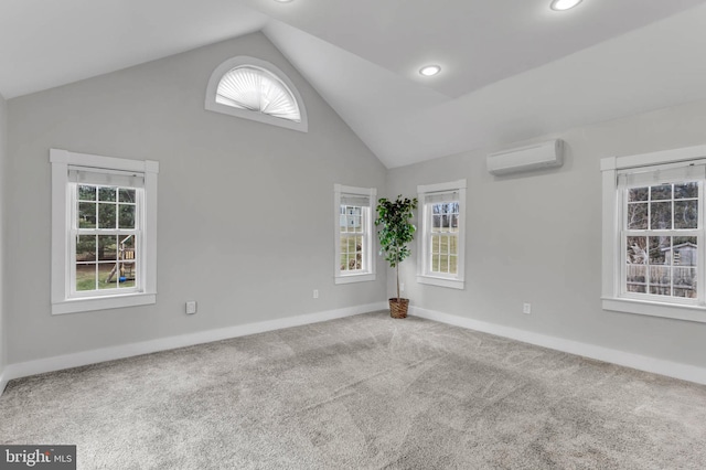 spare room with an AC wall unit, carpet, and high vaulted ceiling