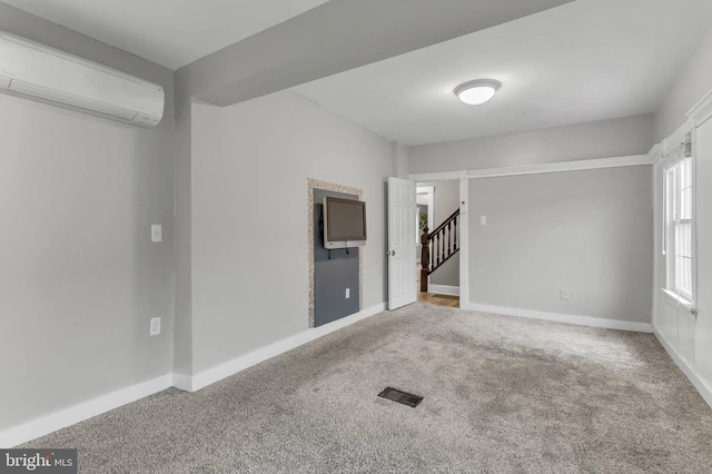 unfurnished room featuring an AC wall unit and carpet