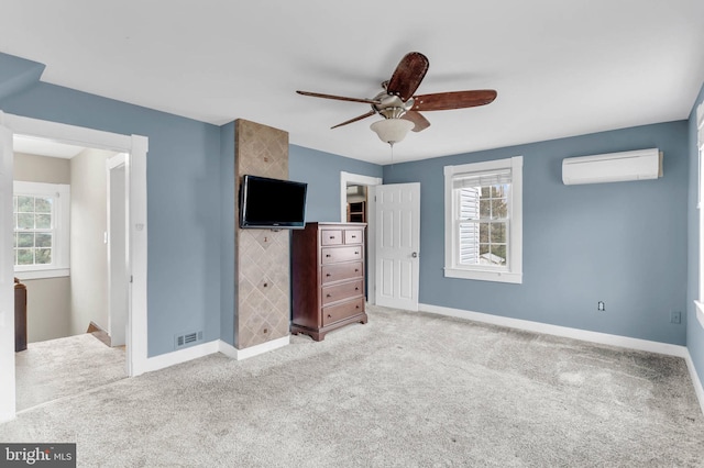 unfurnished bedroom with light carpet, an AC wall unit, and ceiling fan