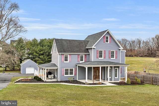 view of front property with an outbuilding, a garage, a front yard, and a porch