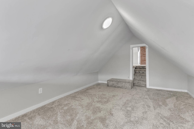 additional living space with vaulted ceiling and carpet flooring