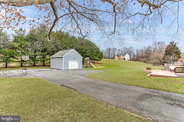 view of yard with a garage, an outdoor structure, and a playground