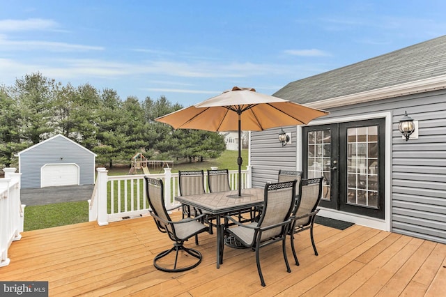 deck featuring an outbuilding, a garage, and french doors