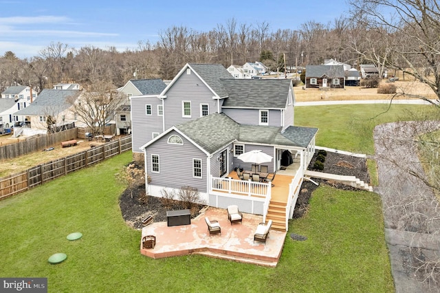 rear view of property featuring a yard, a deck, a patio, and an outdoor living space with a fire pit