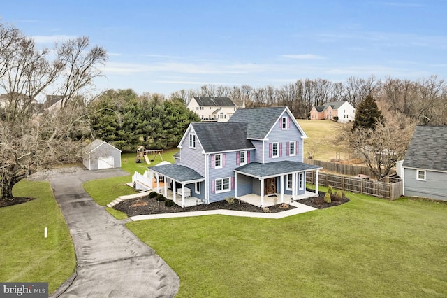 view of front of property featuring a porch, a shed, and a front lawn