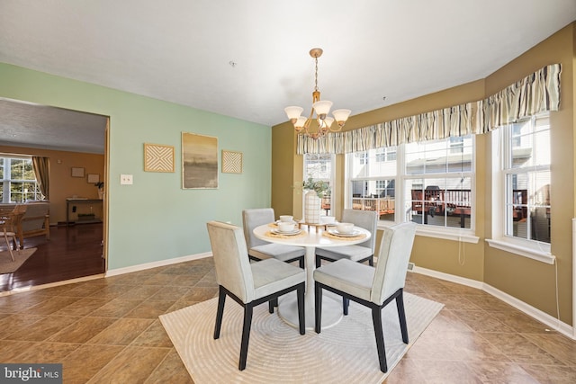 dining space featuring baseboards and a chandelier