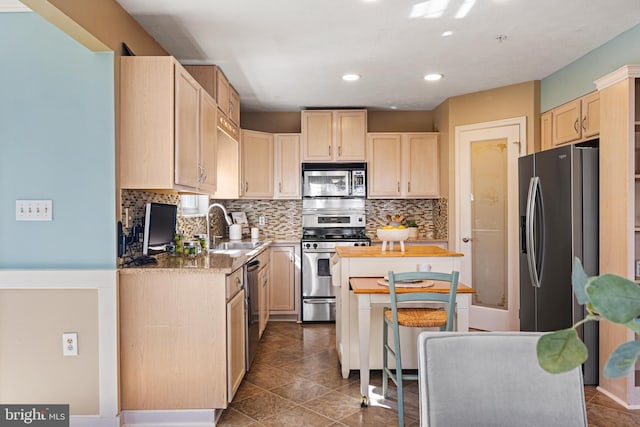 kitchen featuring a sink, stainless steel appliances, decorative backsplash, and light brown cabinetry