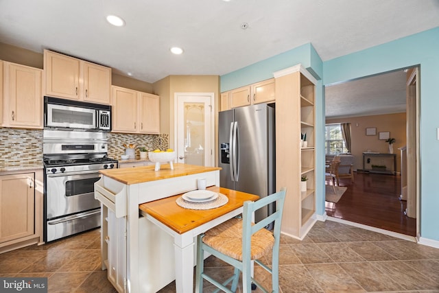 kitchen with recessed lighting, tasteful backsplash, appliances with stainless steel finishes, and wooden counters