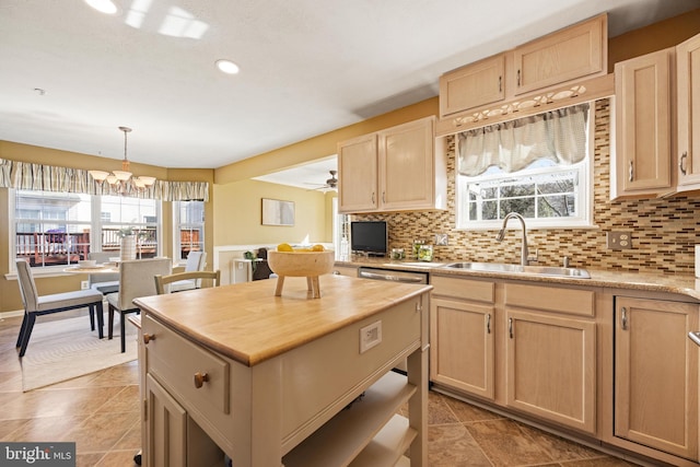 kitchen with light brown cabinets, a kitchen island, butcher block countertops, a sink, and tasteful backsplash