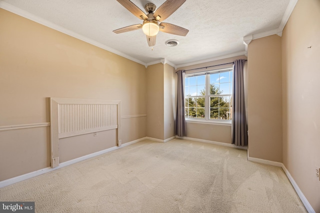 spare room featuring visible vents, baseboards, carpet, and crown molding