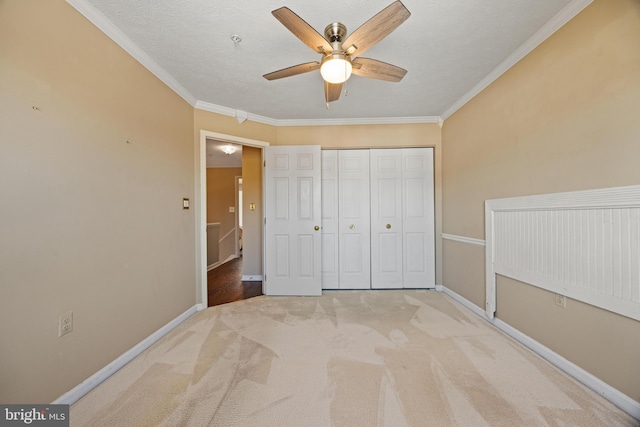 unfurnished bedroom featuring crown molding, carpet flooring, and baseboards