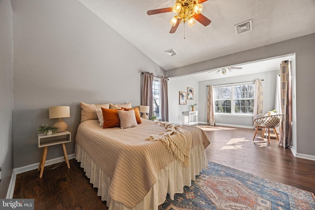 bedroom featuring vaulted ceiling, wood finished floors, visible vents, and baseboards