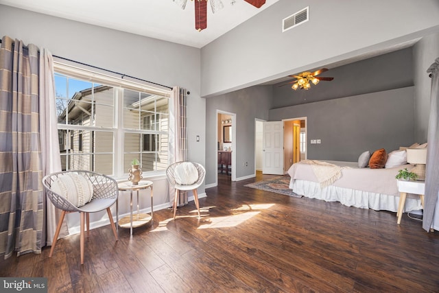 bedroom with visible vents, baseboards, hardwood / wood-style floors, a high ceiling, and a ceiling fan