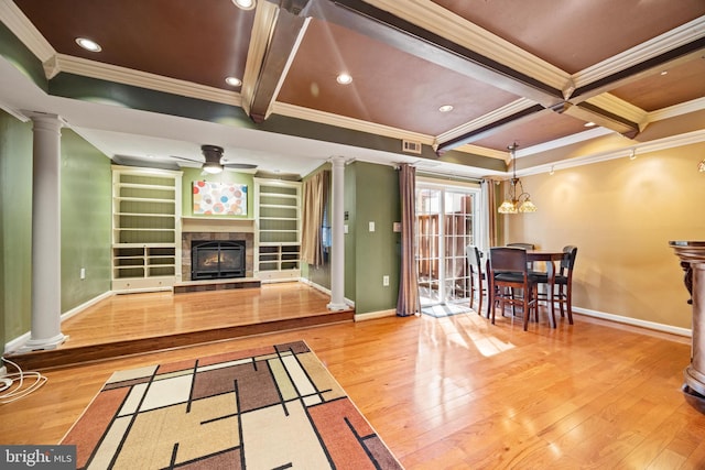 living area with hardwood / wood-style flooring, beamed ceiling, and ornate columns