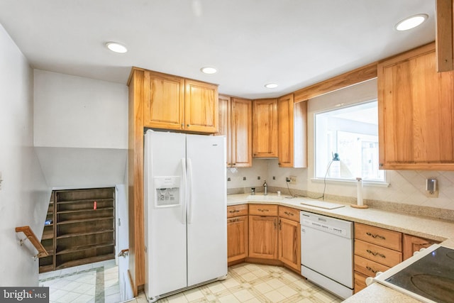 kitchen featuring tasteful backsplash, white appliances, and sink