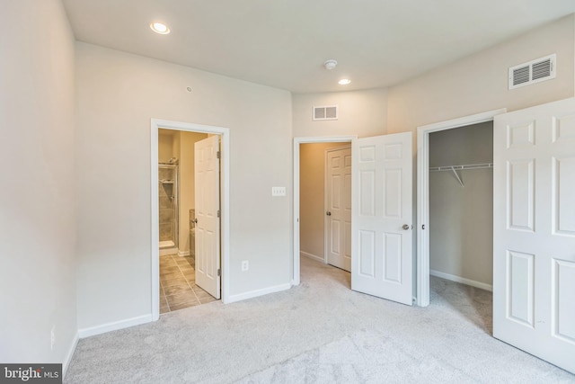 unfurnished bedroom with light colored carpet and a closet