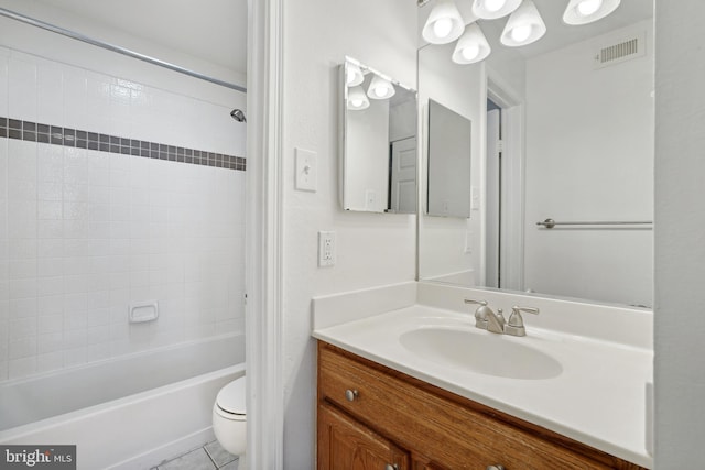 full bathroom with vanity, tiled shower / bath, tile patterned flooring, and toilet