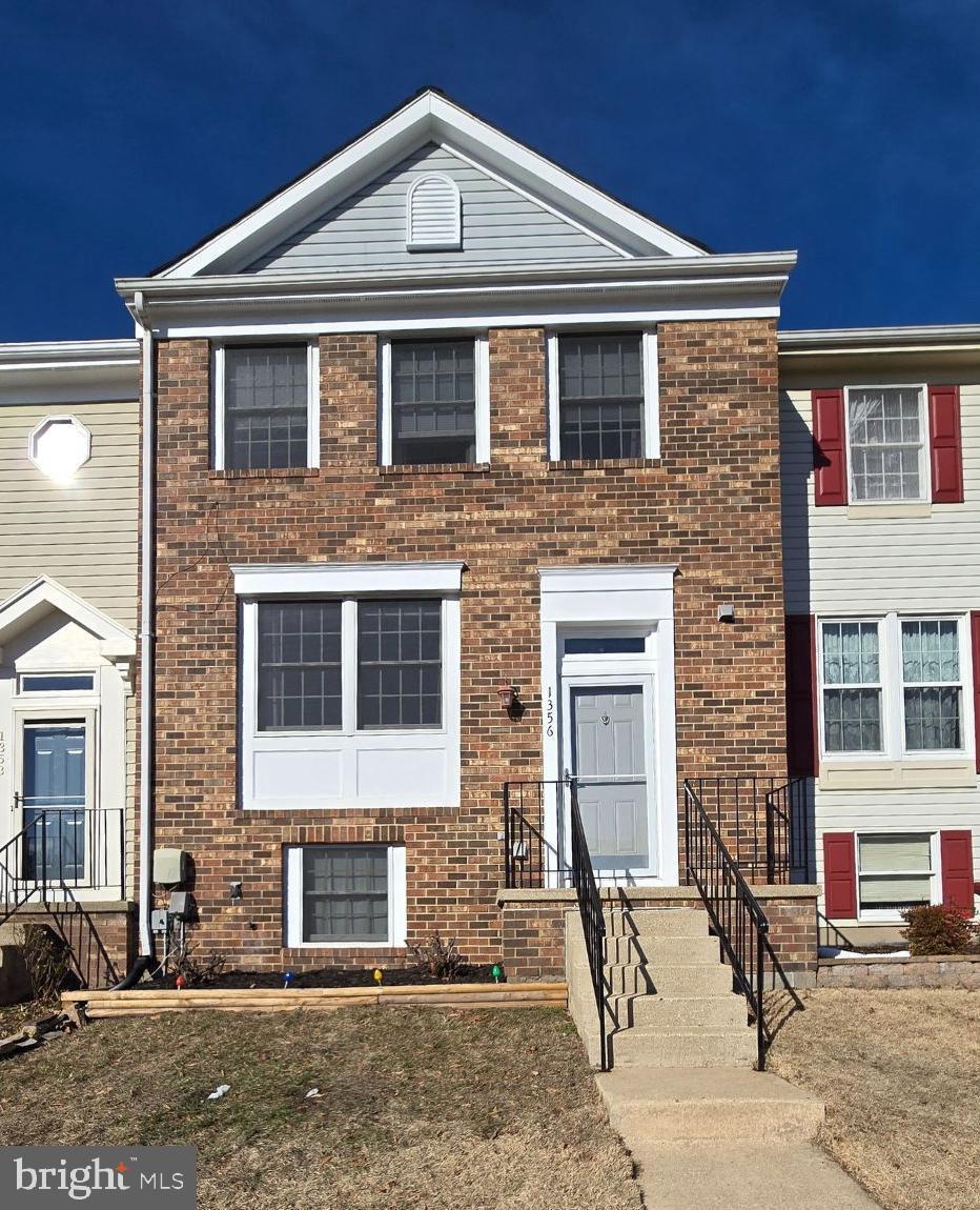 townhome / multi-family property featuring brick siding