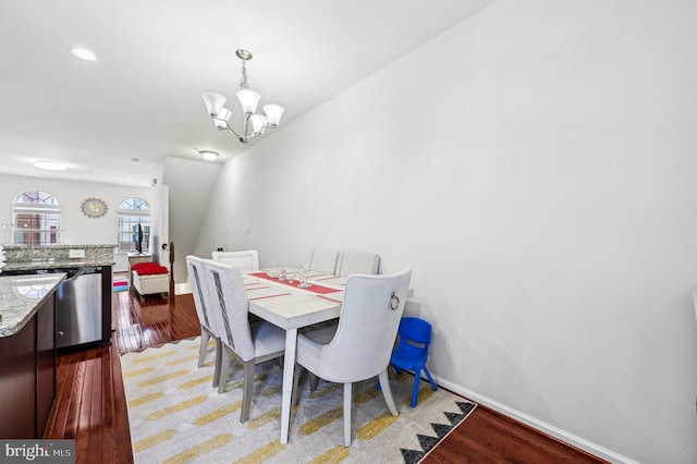 dining space featuring an inviting chandelier and dark hardwood / wood-style flooring