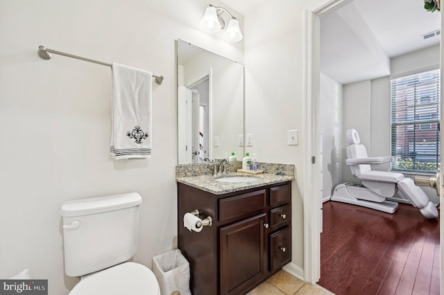 bathroom featuring vanity, hardwood / wood-style floors, and toilet