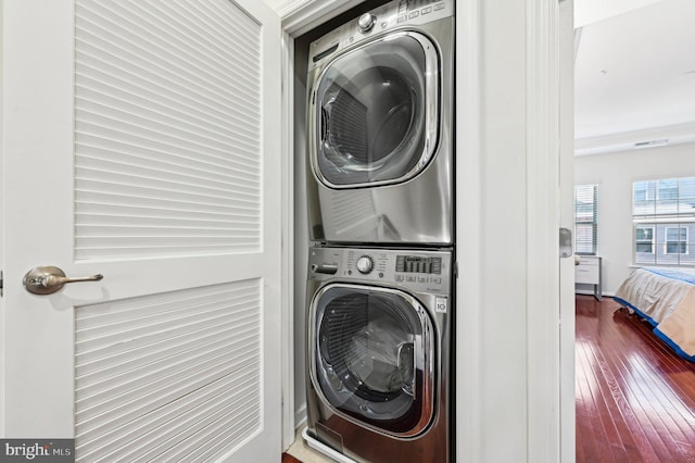 laundry room featuring stacked washer / dryer and hardwood / wood-style floors