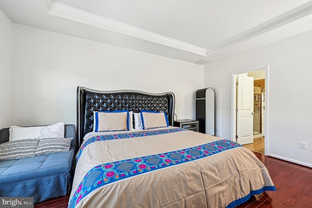 bedroom featuring ornamental molding, a raised ceiling, and wood-type flooring