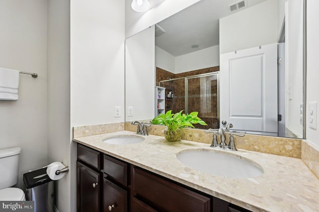 bathroom featuring vanity, toilet, and a shower with shower door