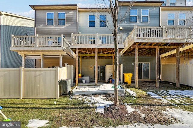 back of house featuring a wooden deck and a lawn