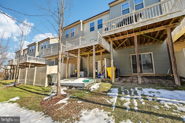 snow covered rear of property featuring a deck