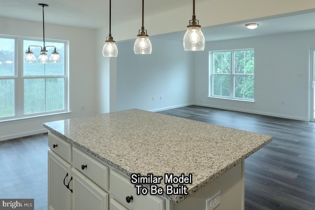 kitchen with light stone counters, decorative light fixtures, dark wood-type flooring, and white cabinets