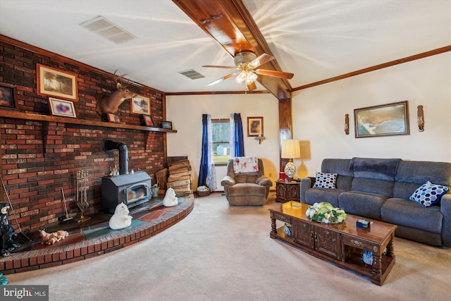 living room with ceiling fan, ornamental molding, brick wall, light colored carpet, and a wood stove