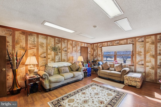 living room with wood-type flooring, a textured ceiling, and crown molding