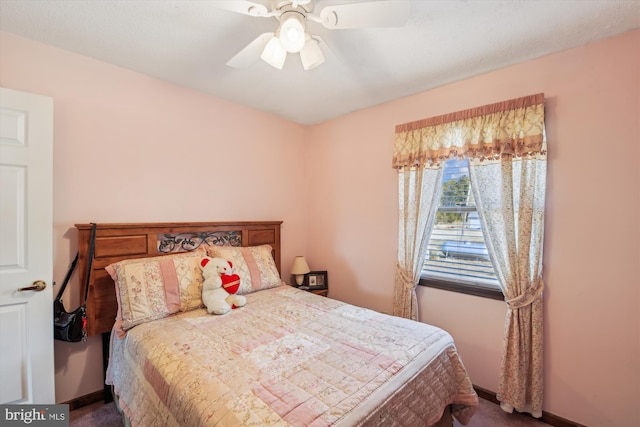 bedroom featuring ceiling fan and dark colored carpet