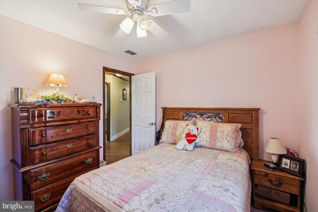 bedroom with dark hardwood / wood-style floors and ceiling fan