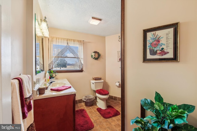 bathroom with vanity, a textured ceiling, and toilet