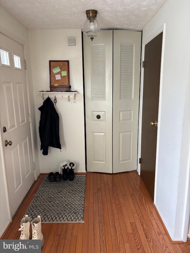 mudroom with hardwood / wood-style flooring and a textured ceiling