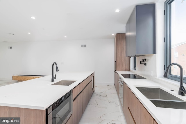 kitchen with a spacious island, black electric cooktop, and sink