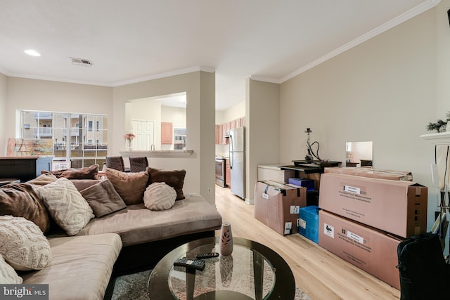 living room featuring crown molding and light hardwood / wood-style floors