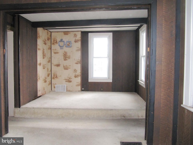 empty room with beamed ceiling and light carpet