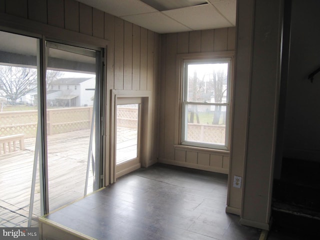 unfurnished dining area featuring hardwood / wood-style floors and wooden walls