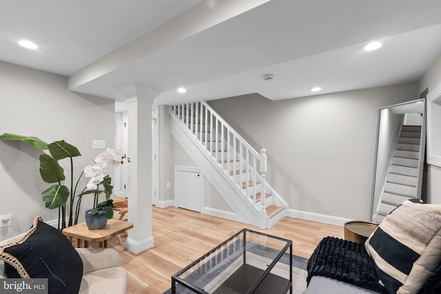 living room featuring decorative columns and light wood-type flooring