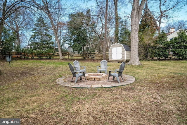 view of yard with a storage shed, an outdoor fire pit, a patio area, fence, and an outdoor structure